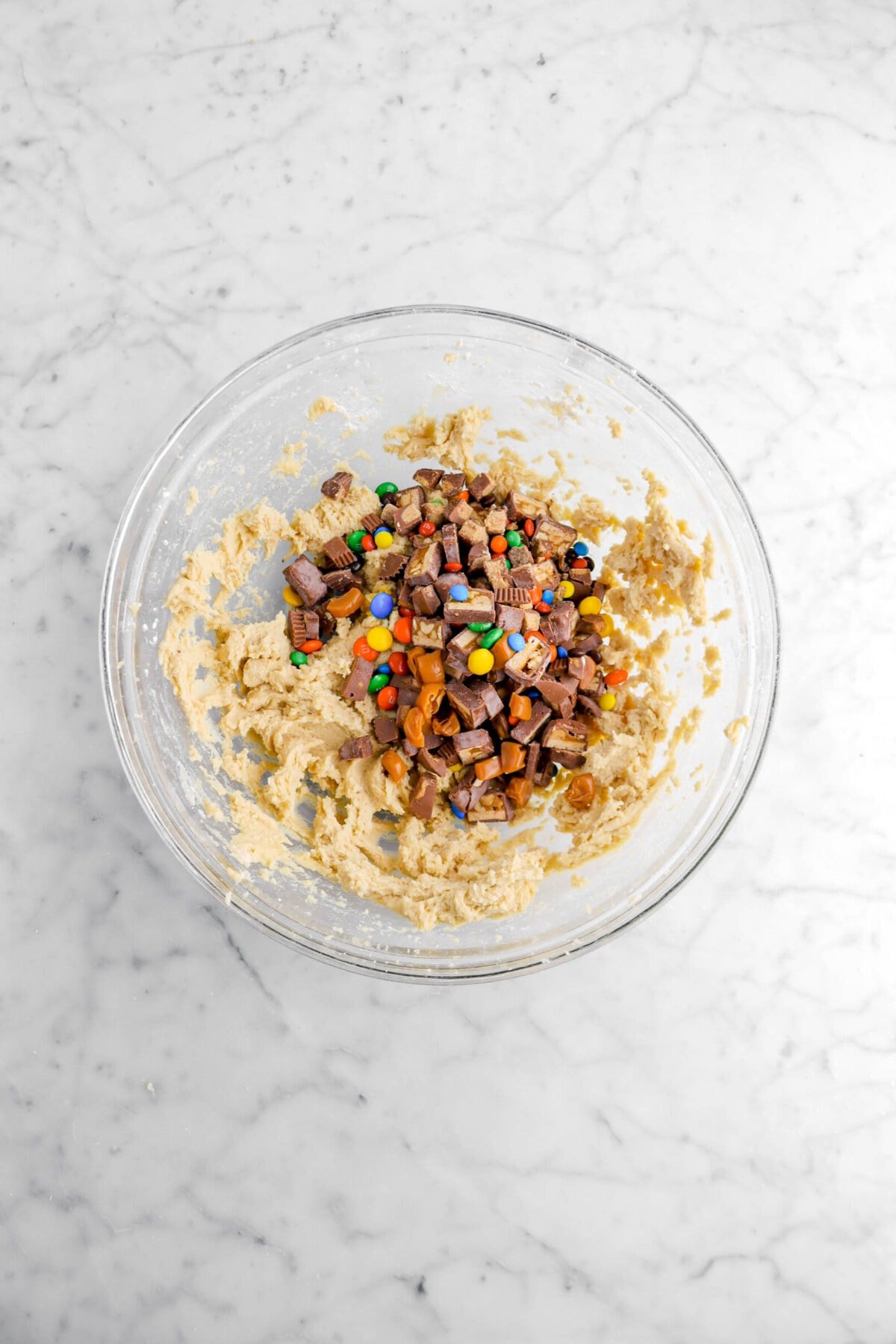 chopped halloween candy added to mixing bowl with cookie dough.