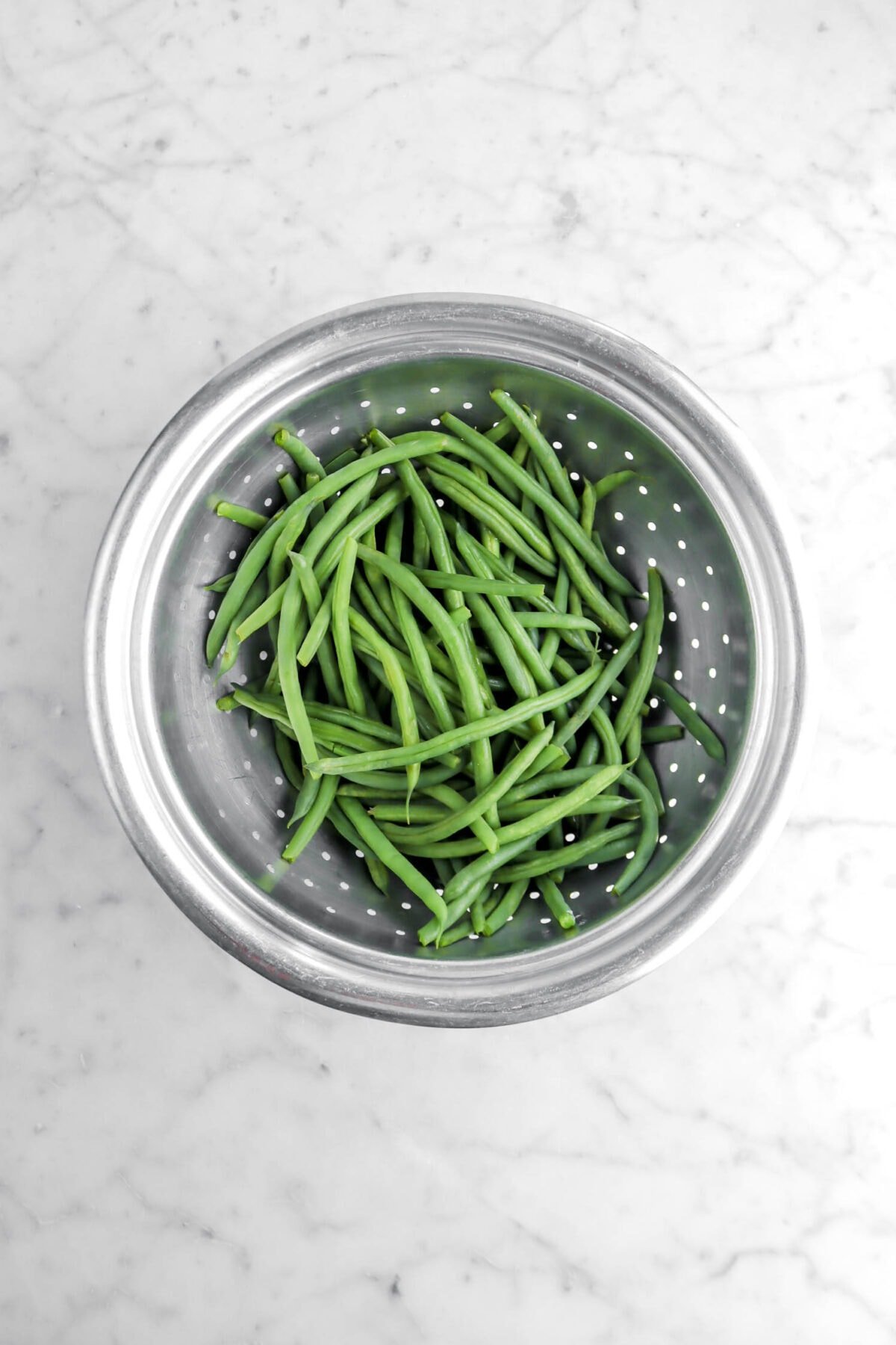 blanched green beans in colander.
