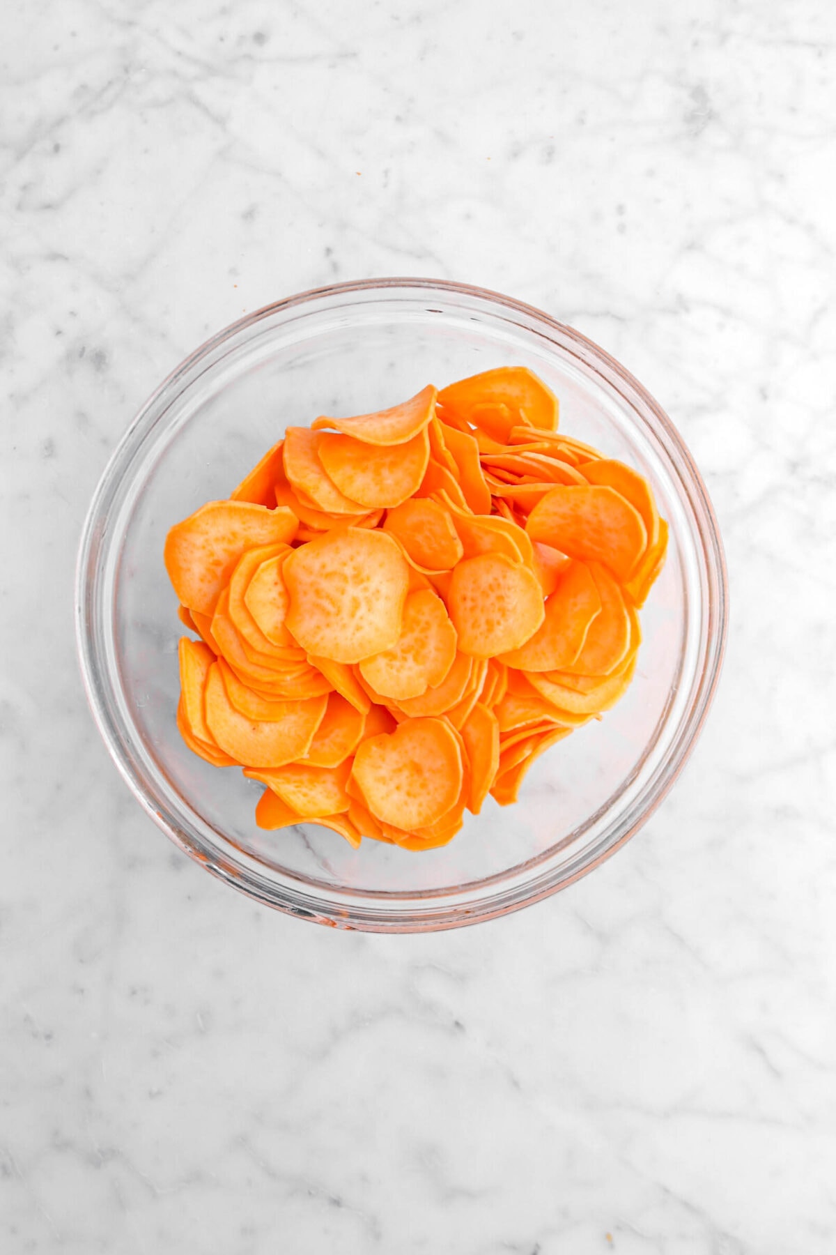 sliced sweet potatoes in glass bowl.