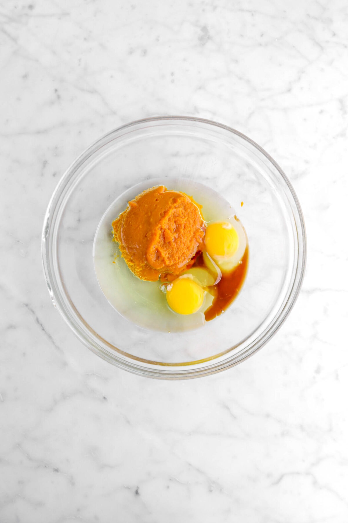 pumpkin purée, vegetable oil, eggs, and vanilla in glass bowl.