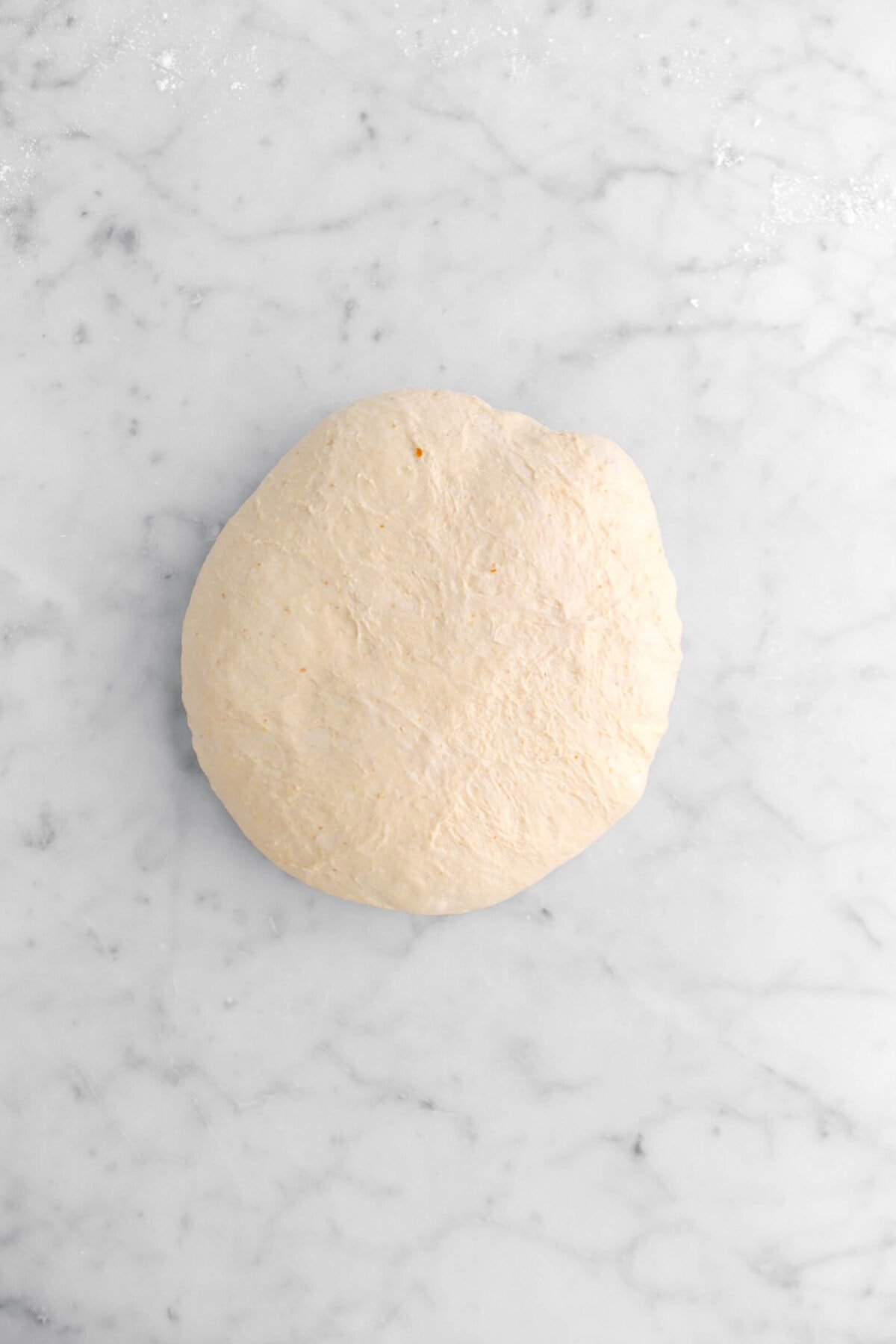 dough boule on marble surface.