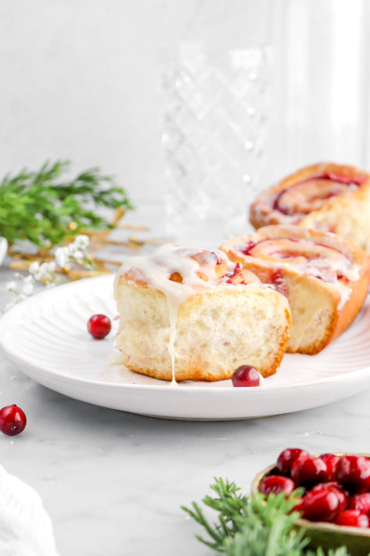 close up of cranberry sweet roll with icing dripping down the side.