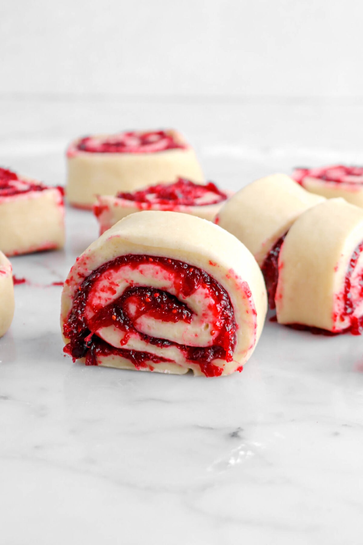 cut sweet rolls filled with cranberry am on marble surface.