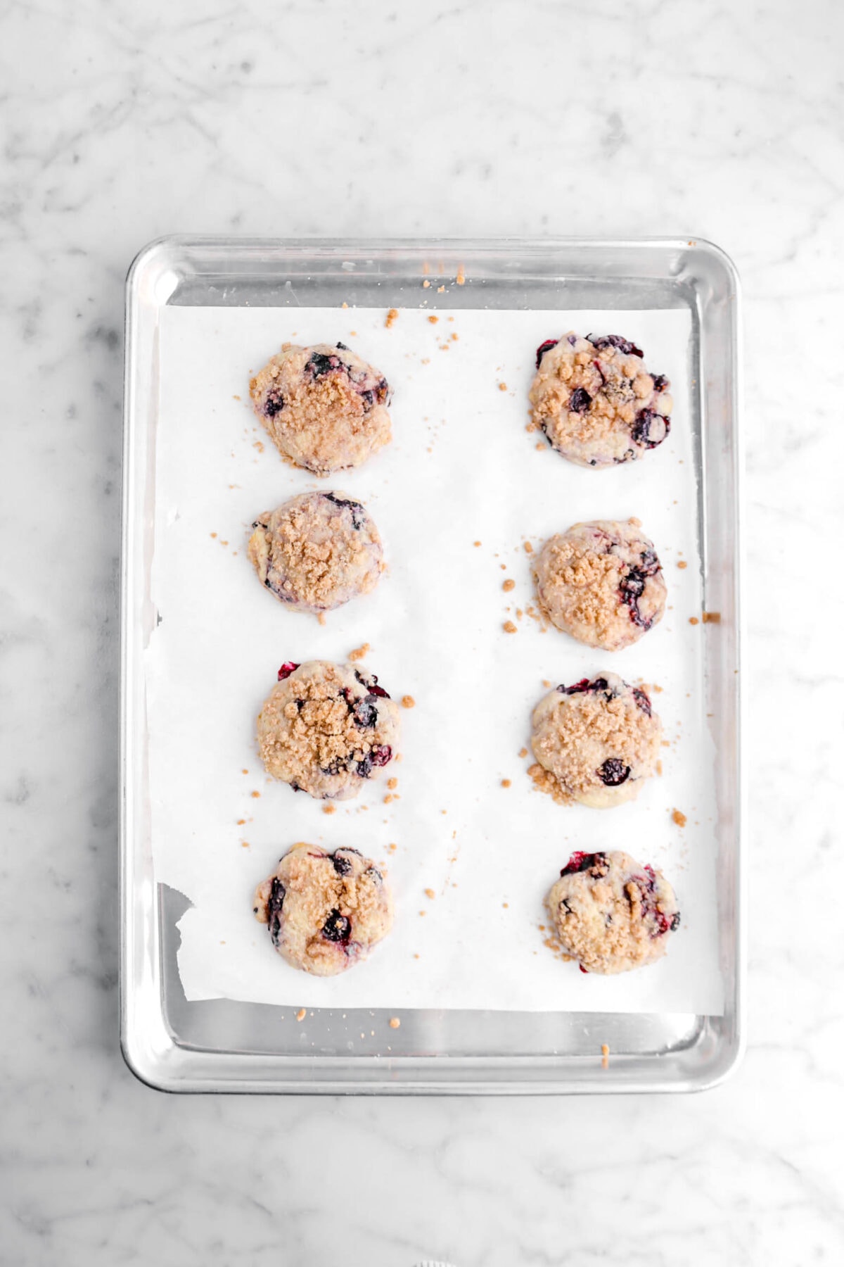 baked blueberry muffin cookies on lined sheet pan.