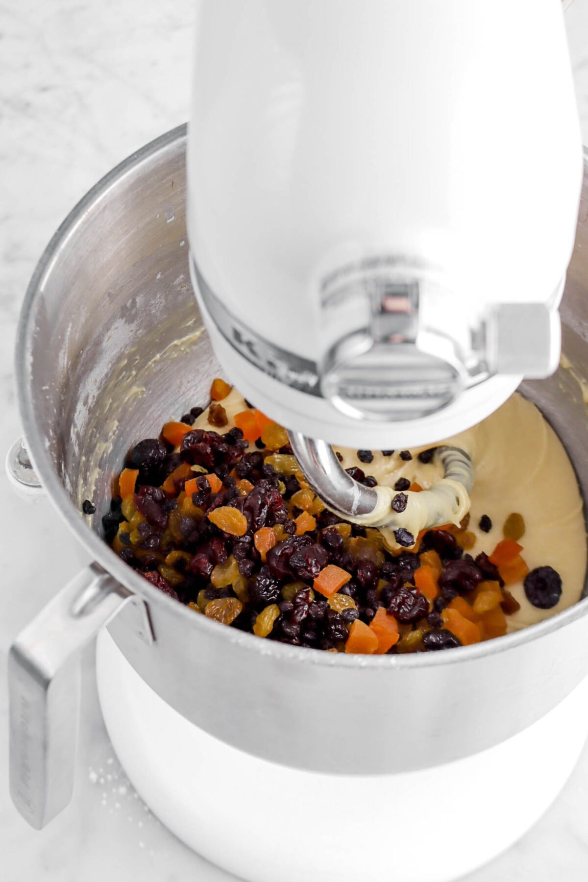dried fruit mixture added to mixer bowl with smooth dough.