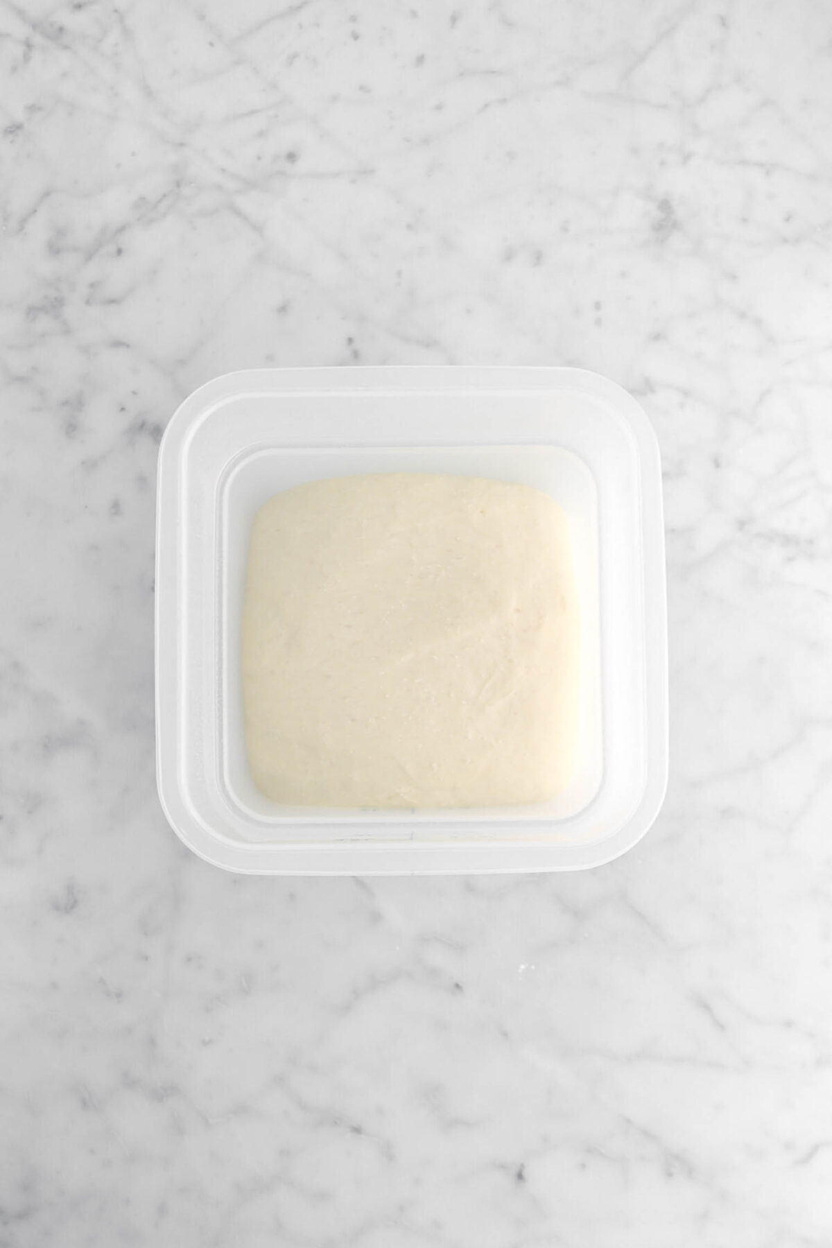 proofed dough in square container.