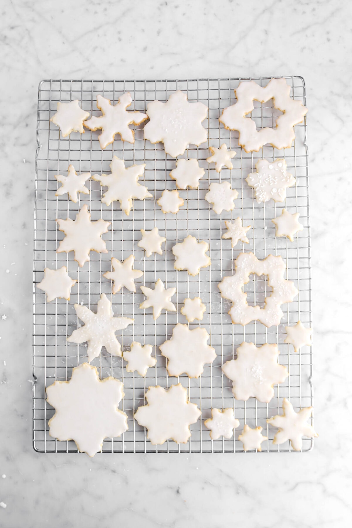 iced snowflake cookies on wire cooling rack.