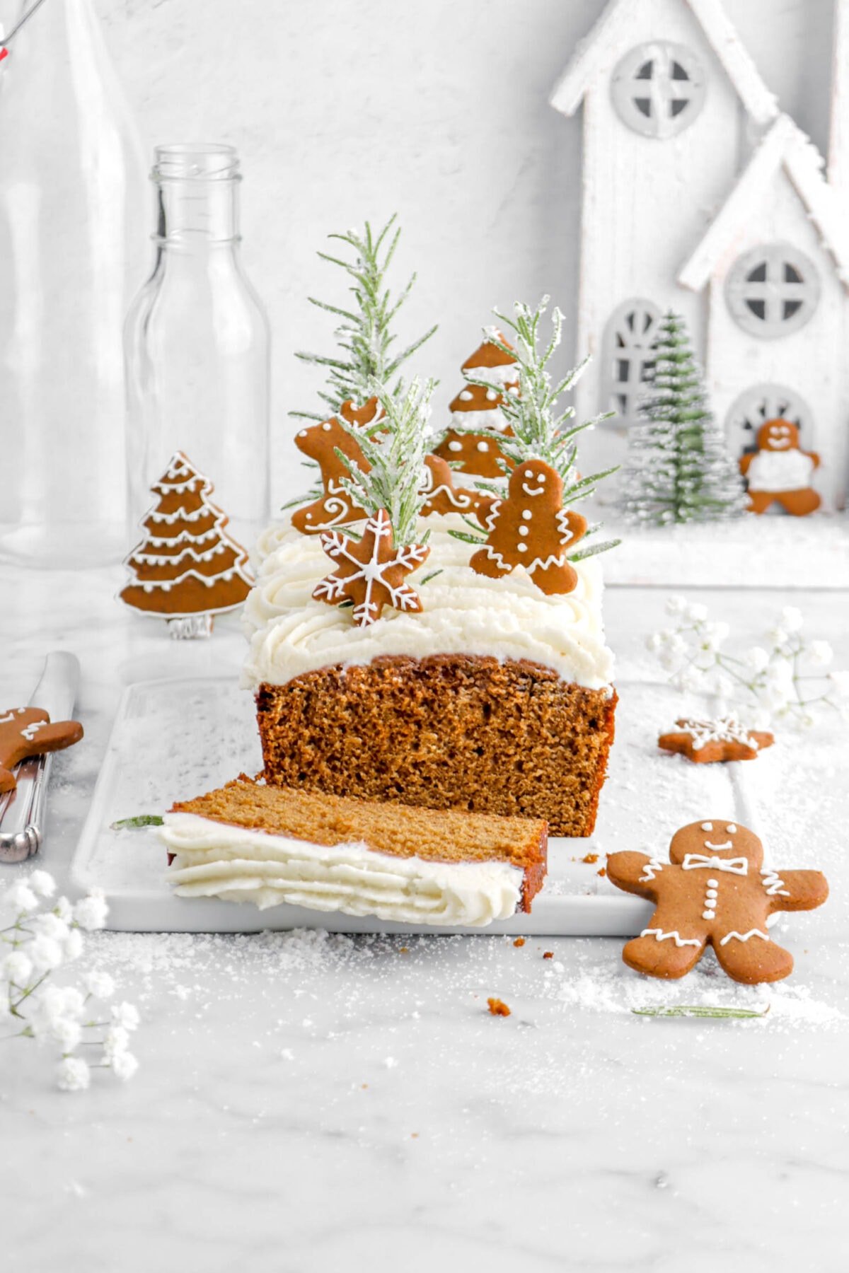 gingerbread loaf cake with slice laying in front on white tray.