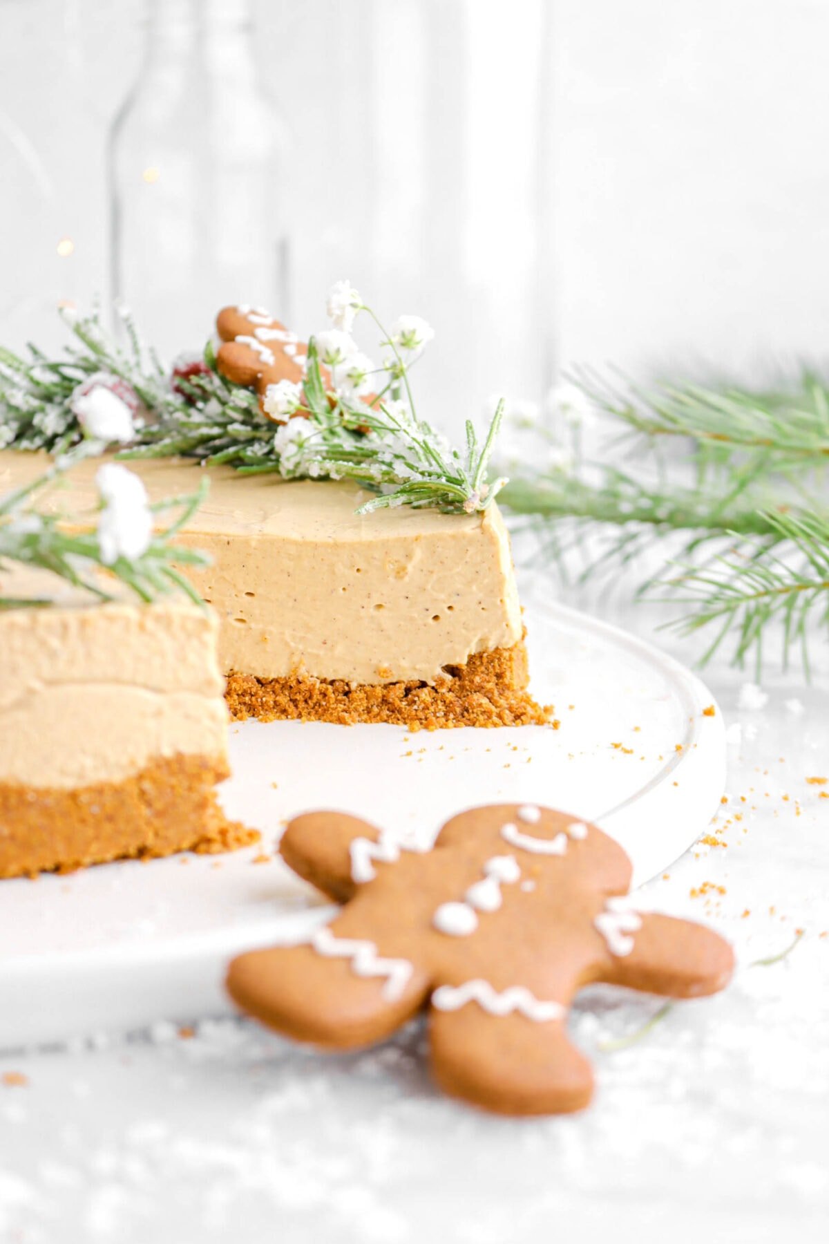 close up of sliced gingerbread cheesecake with gingerbread cookie in front.
