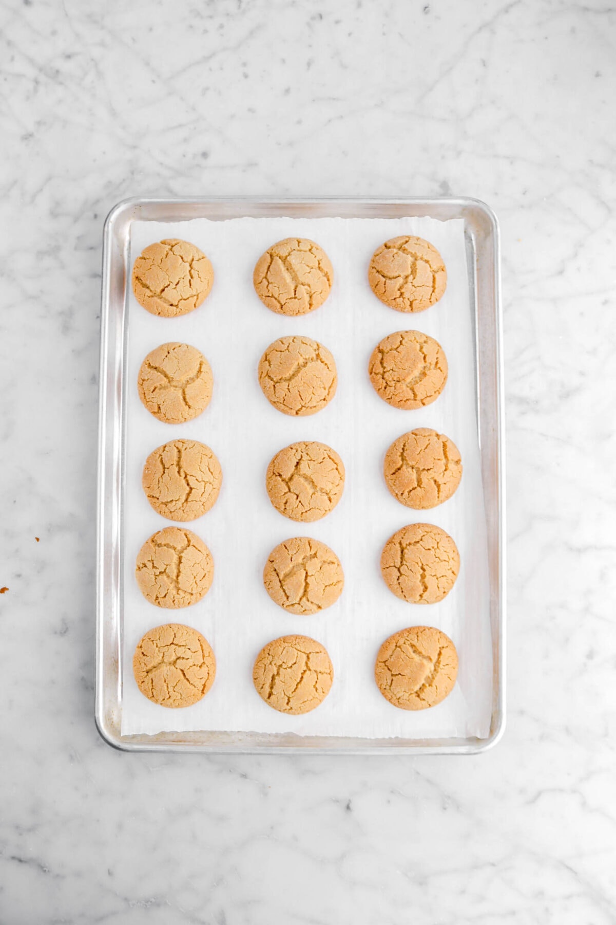 baked peanut butter cookies on lined sheet pan.