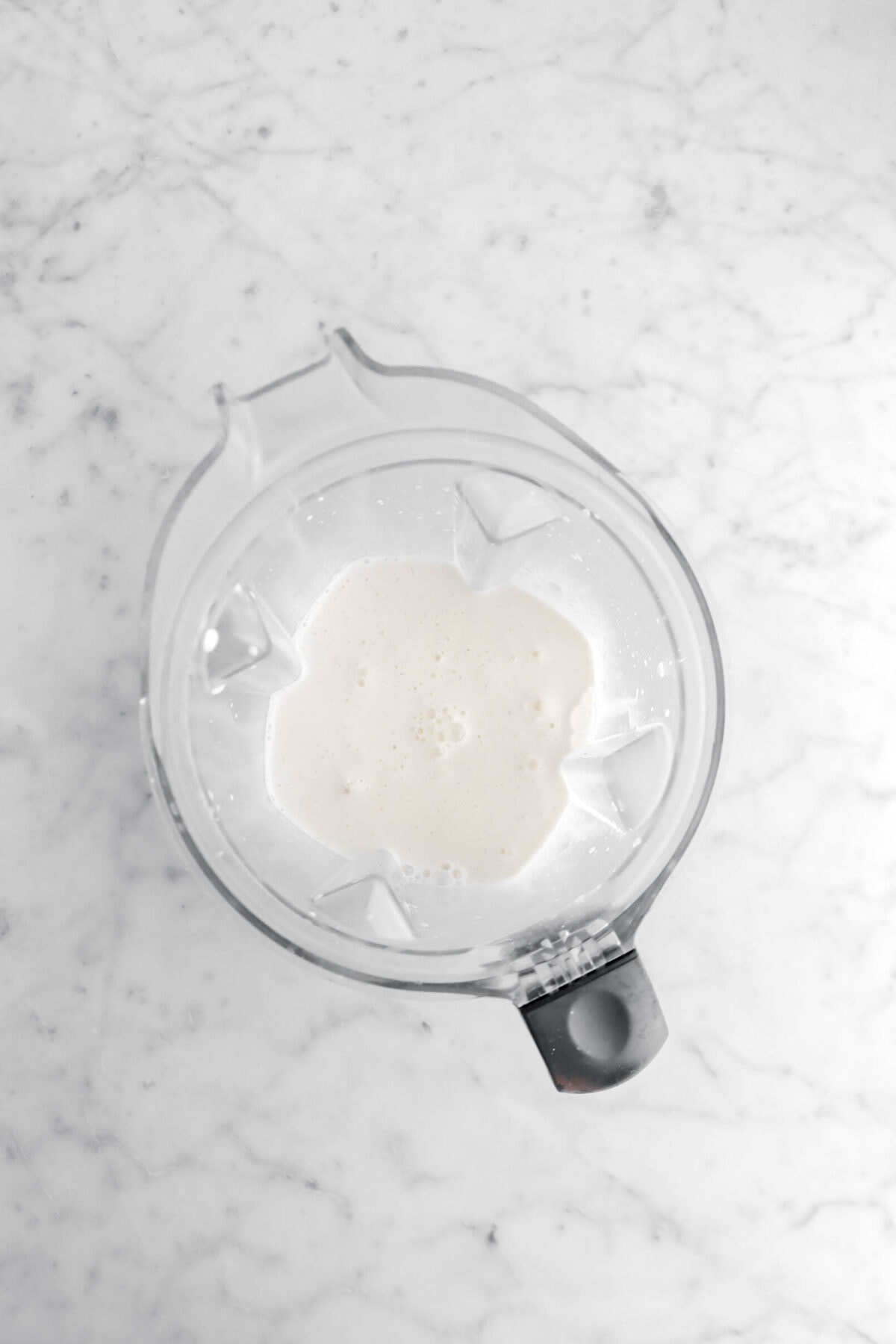 milkshake in blender on marble surface.