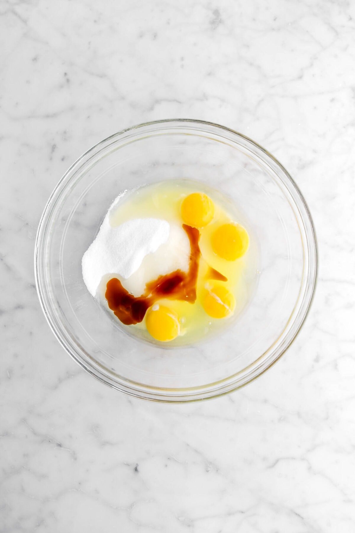 sugar, eggs, and vanilla in glass bowl.