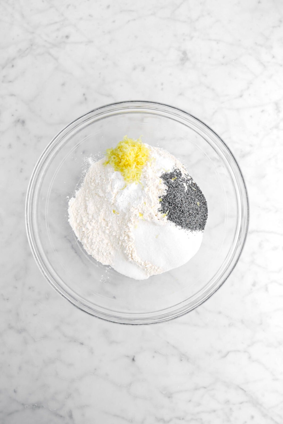 flour, salt, sugar, poppy seeds, baking powder, baking soda, and lemon zest in glass bowl.