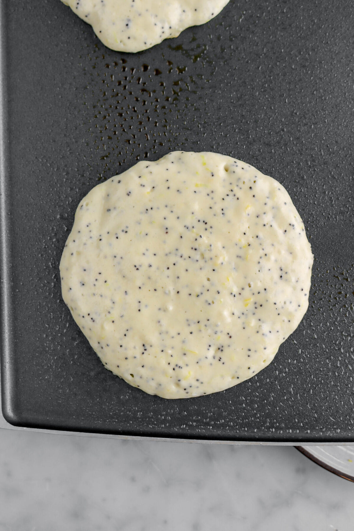 raw pancake on greased griddle.