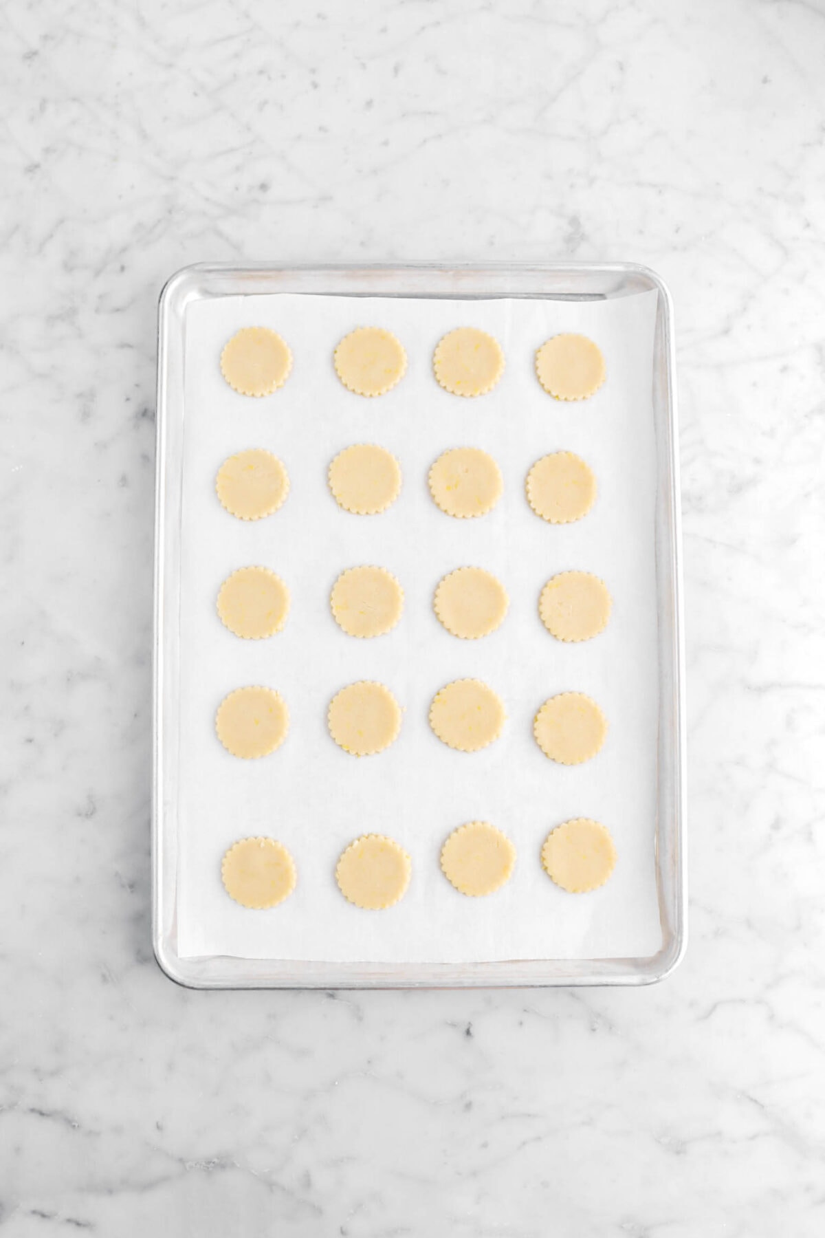 20 unbaked cookies on lined sheet pan.