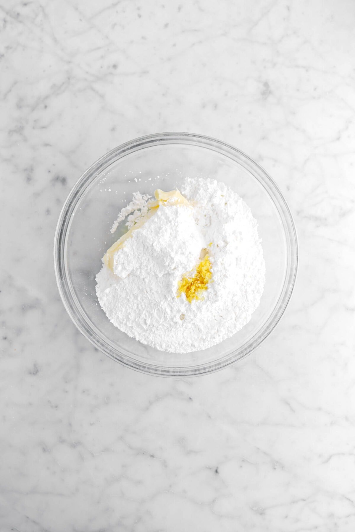 butter, powdered sugar, lemon juice, and lemon zest in glass bowl.