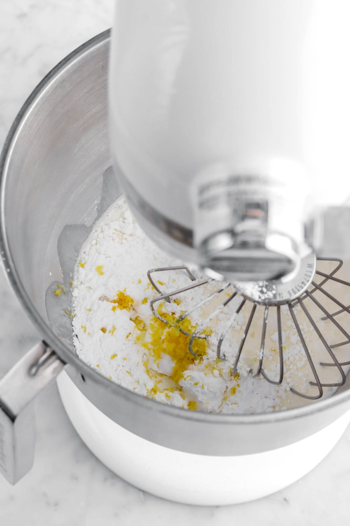 cream, powdered sugar, and lemon zest in stand mixer.