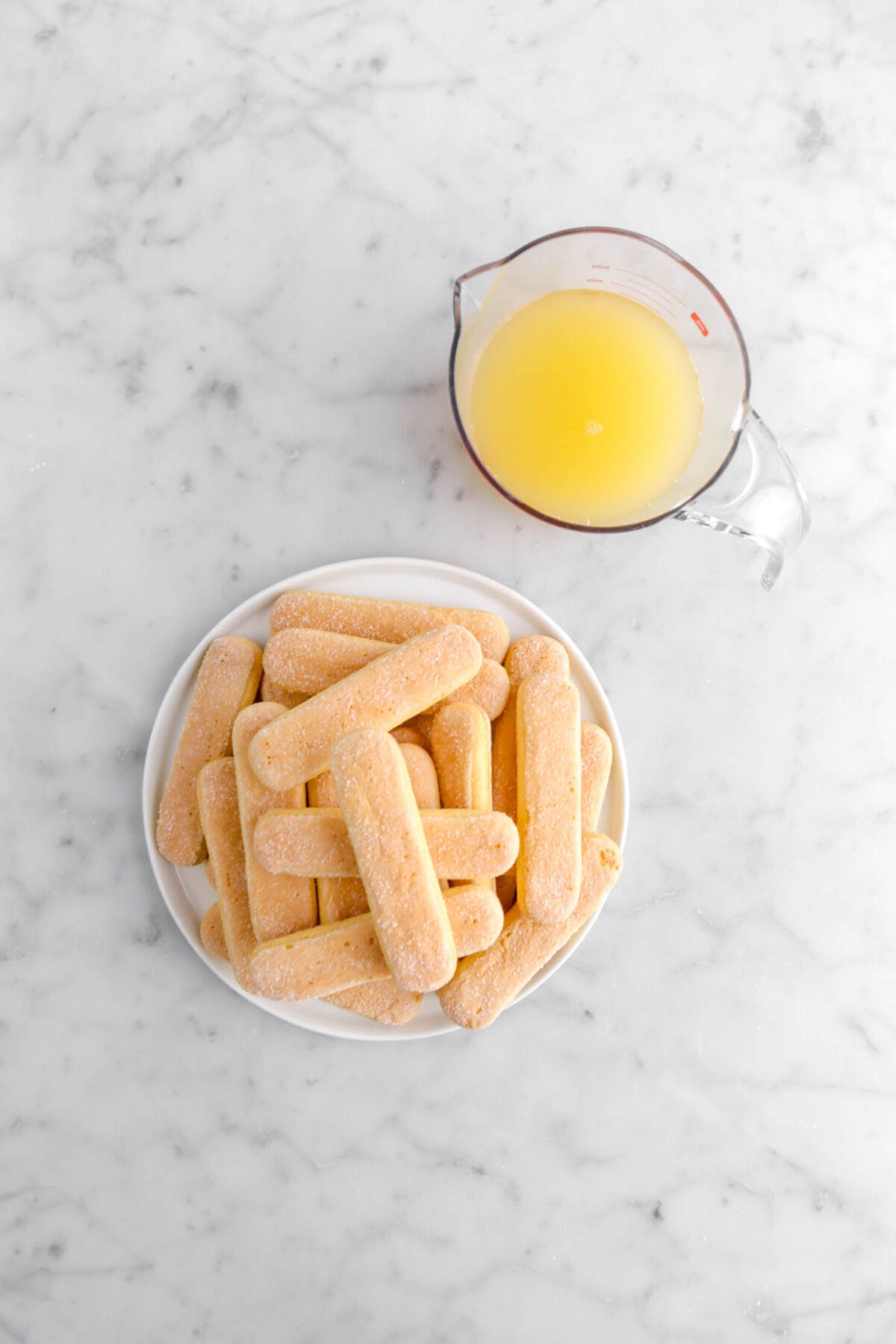 ladyfinger cookies and limoncello on marble surface.