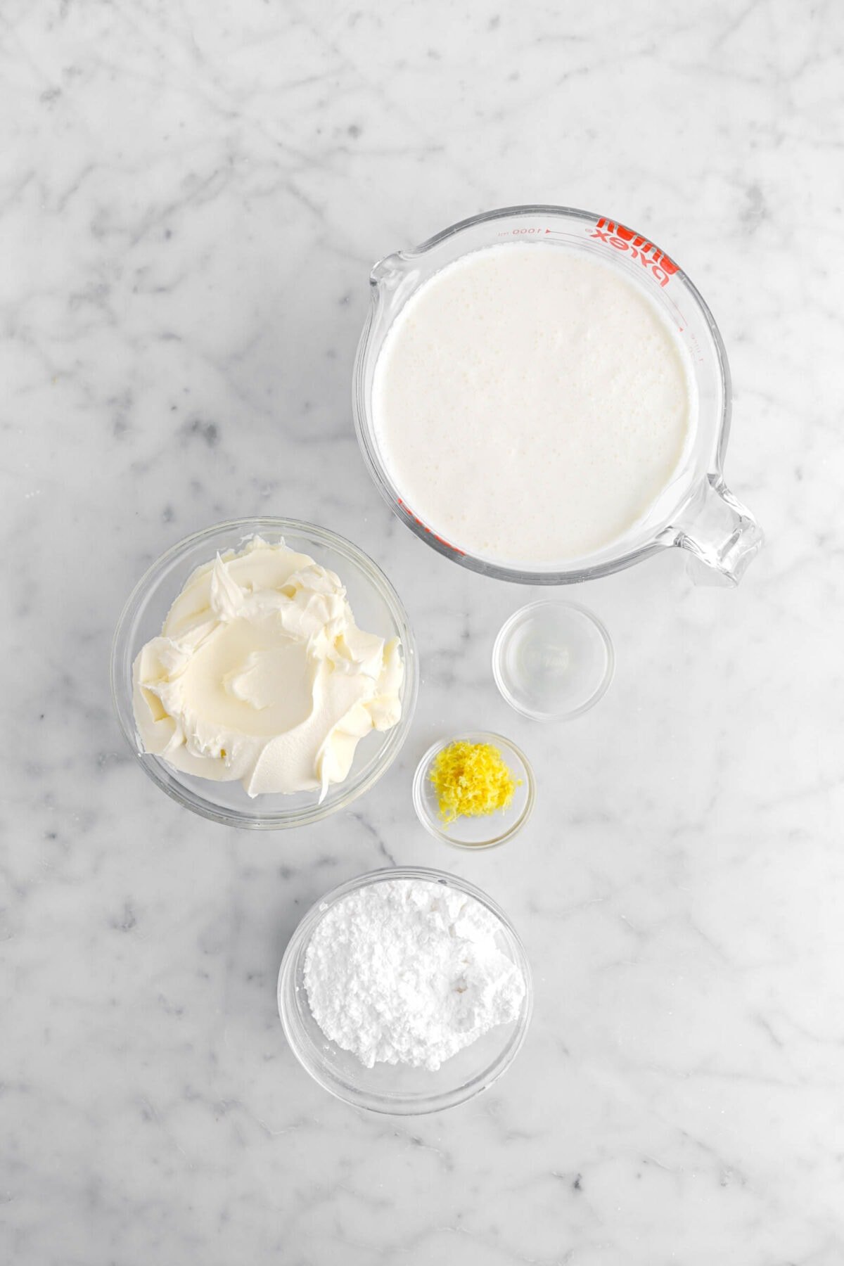 heavy cream, mascarpone, lemon juice, lemon zest, and powdered sugar on marble surface.