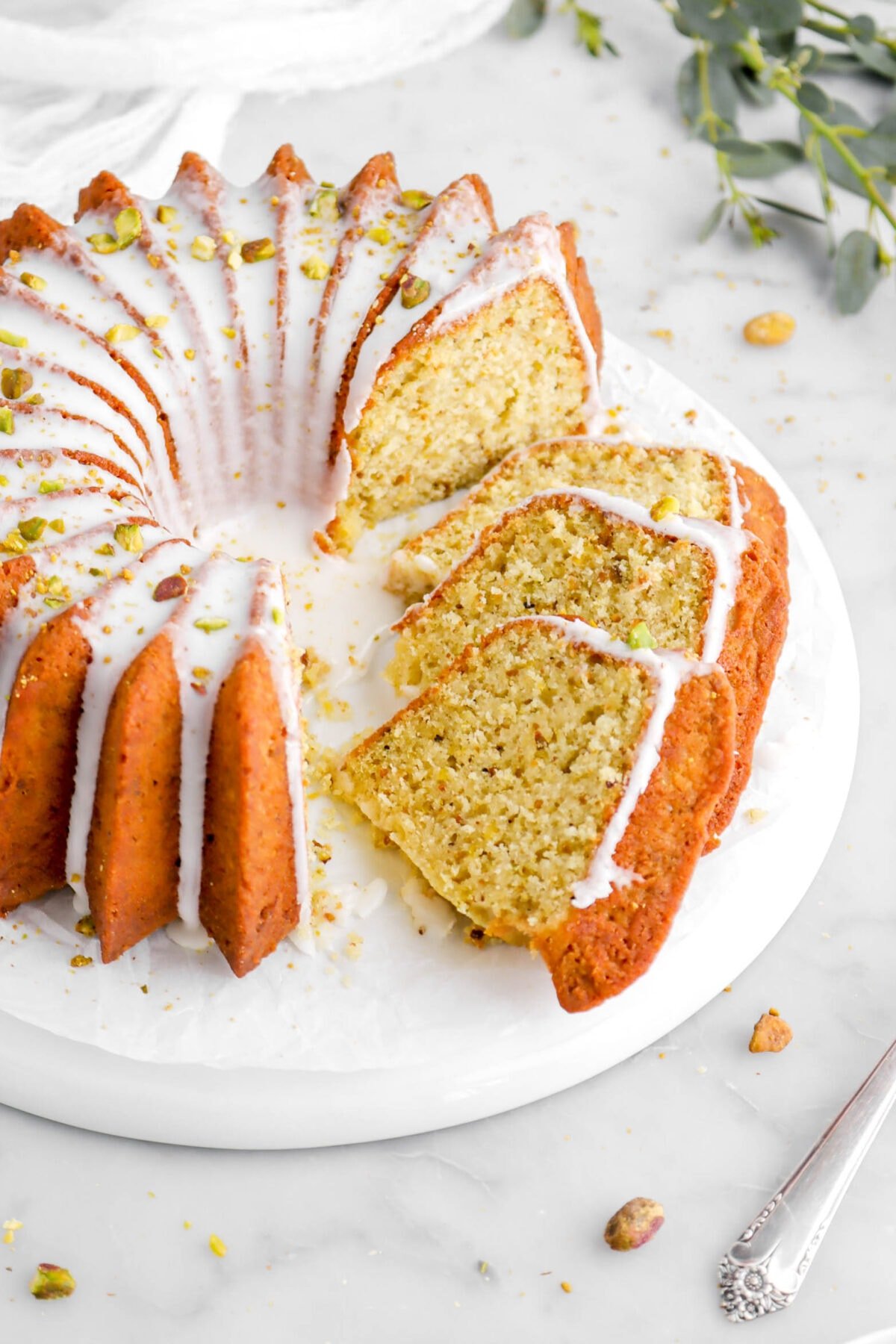 angled close up of three slices of cake laying beside bundt cake on upside down white plate.