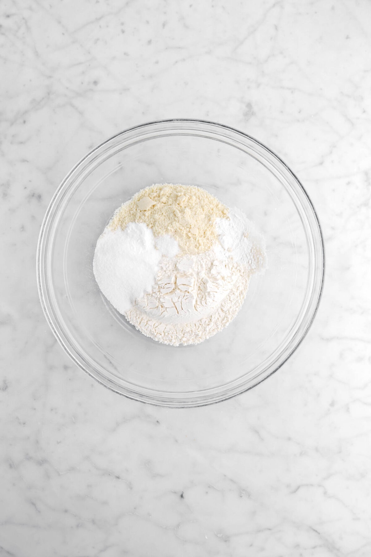 flour, sugar, baking soda, salt, almond flour, and baking powder in glass bowl.