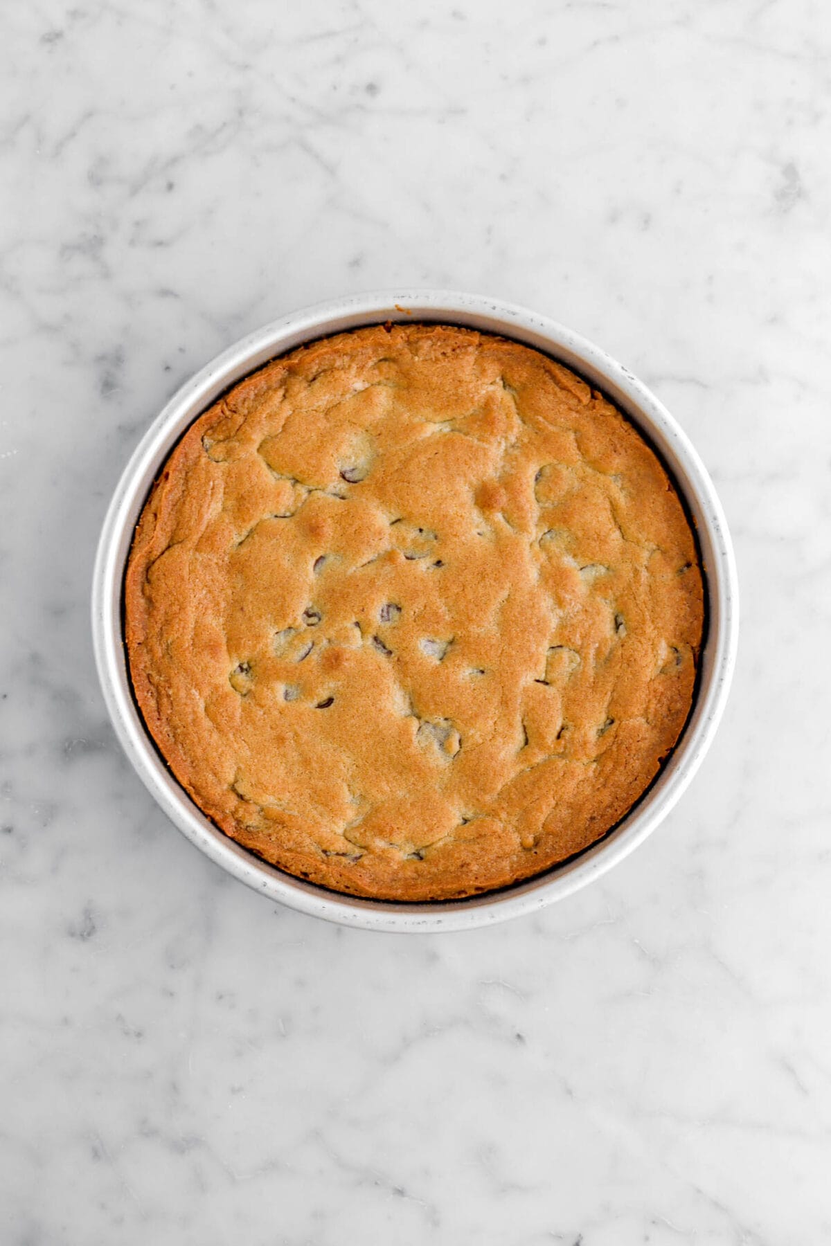baked chocolate chip cookie in large cake pan.
