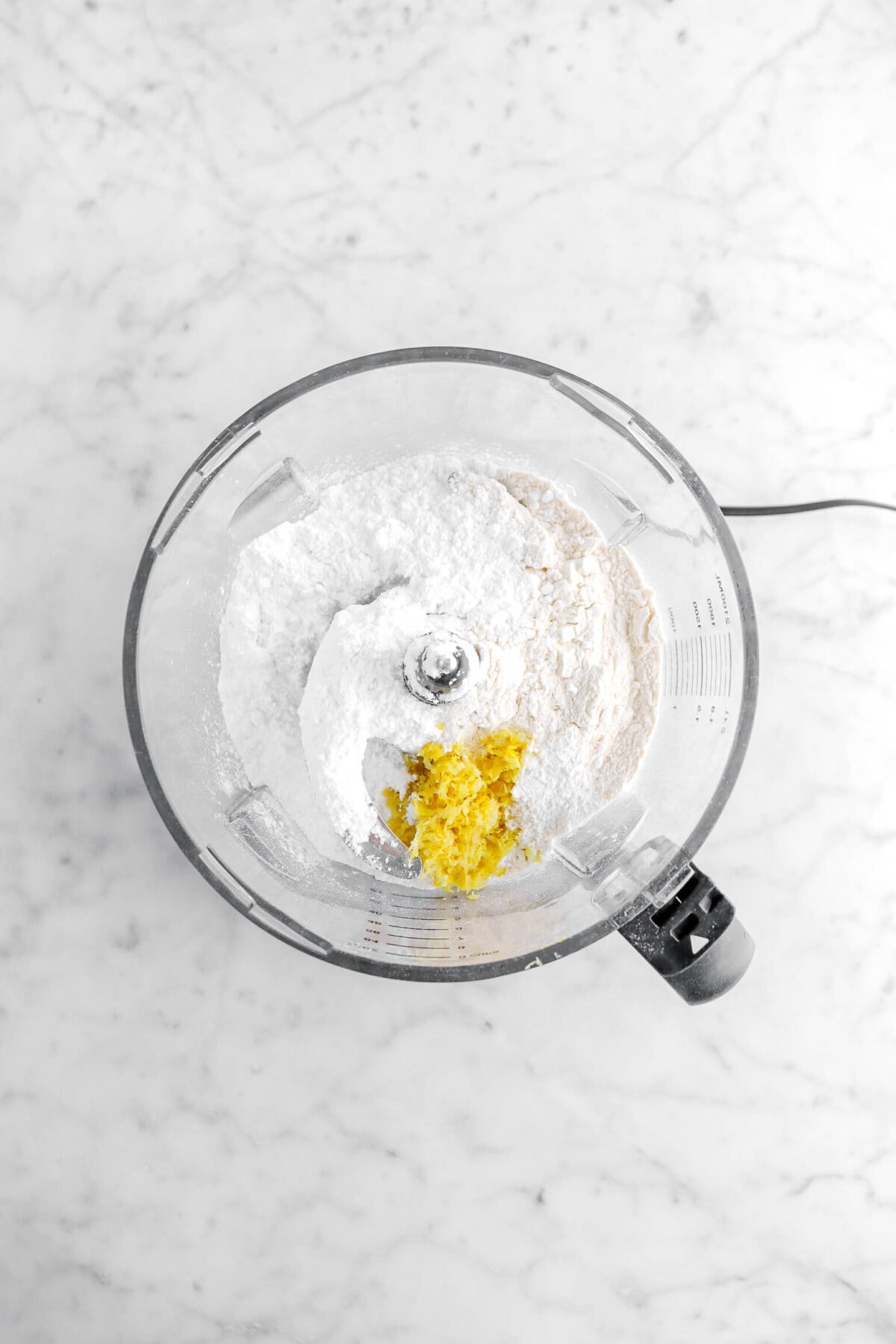 flour, powdered sugar, and lemon zest in food processor.