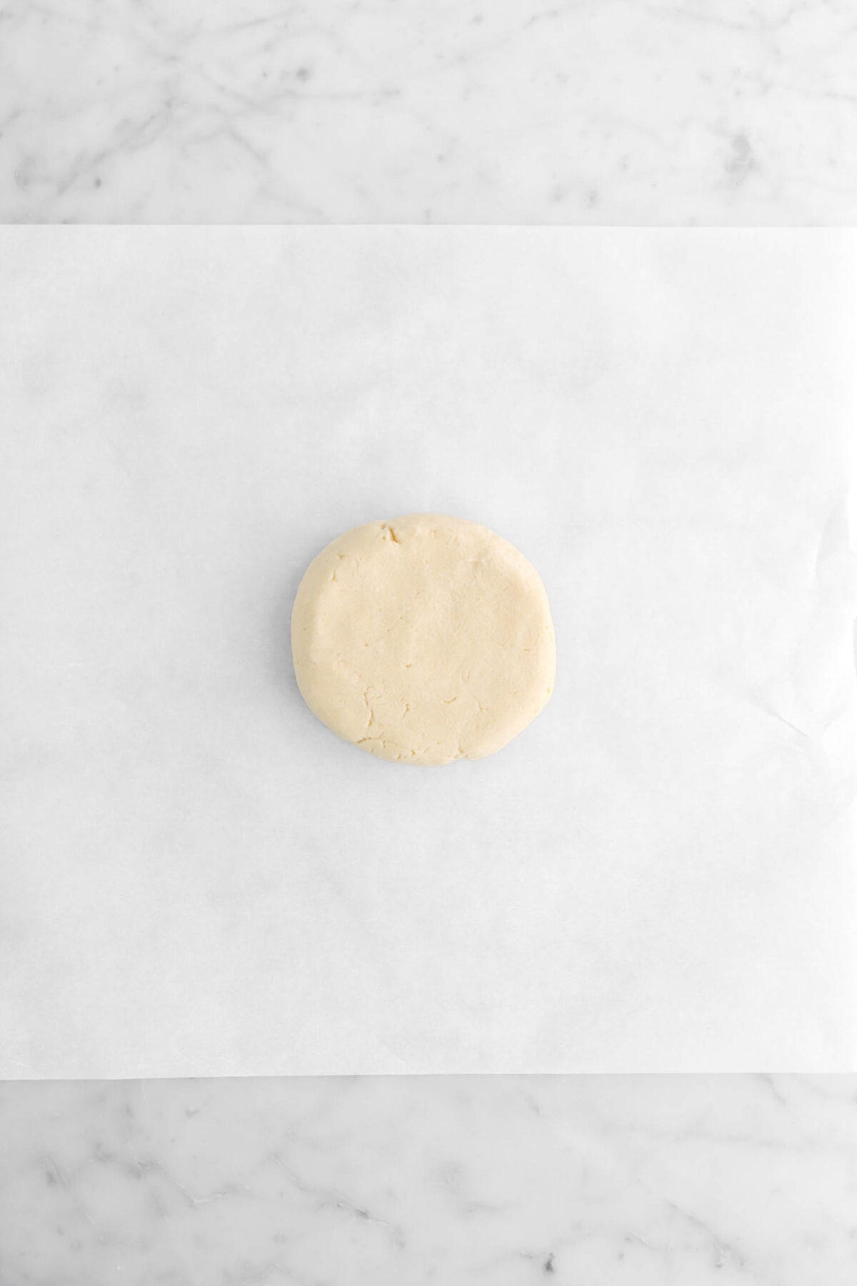 shortbread formed into a round on parchment paper.