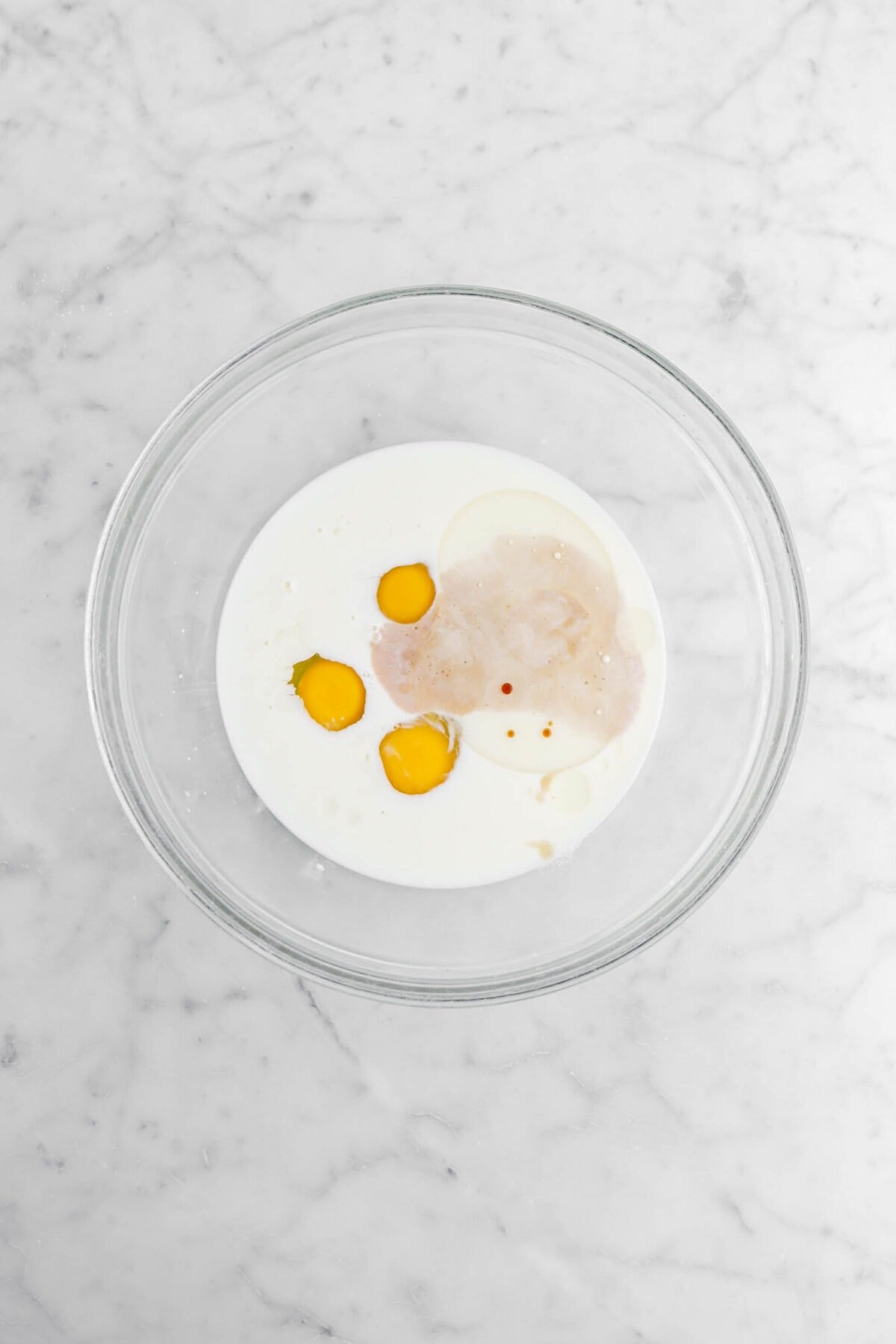 milk, eggs, and vanilla in glass bowl.