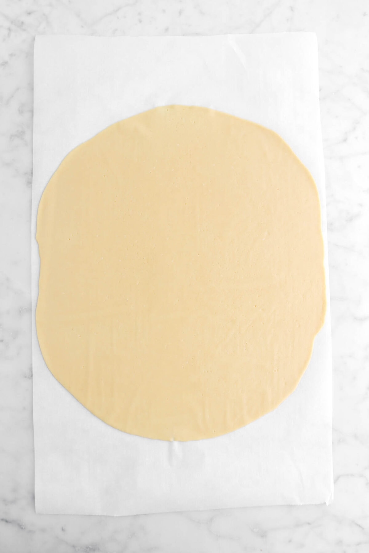 tart dough rolled out on parchment paper.