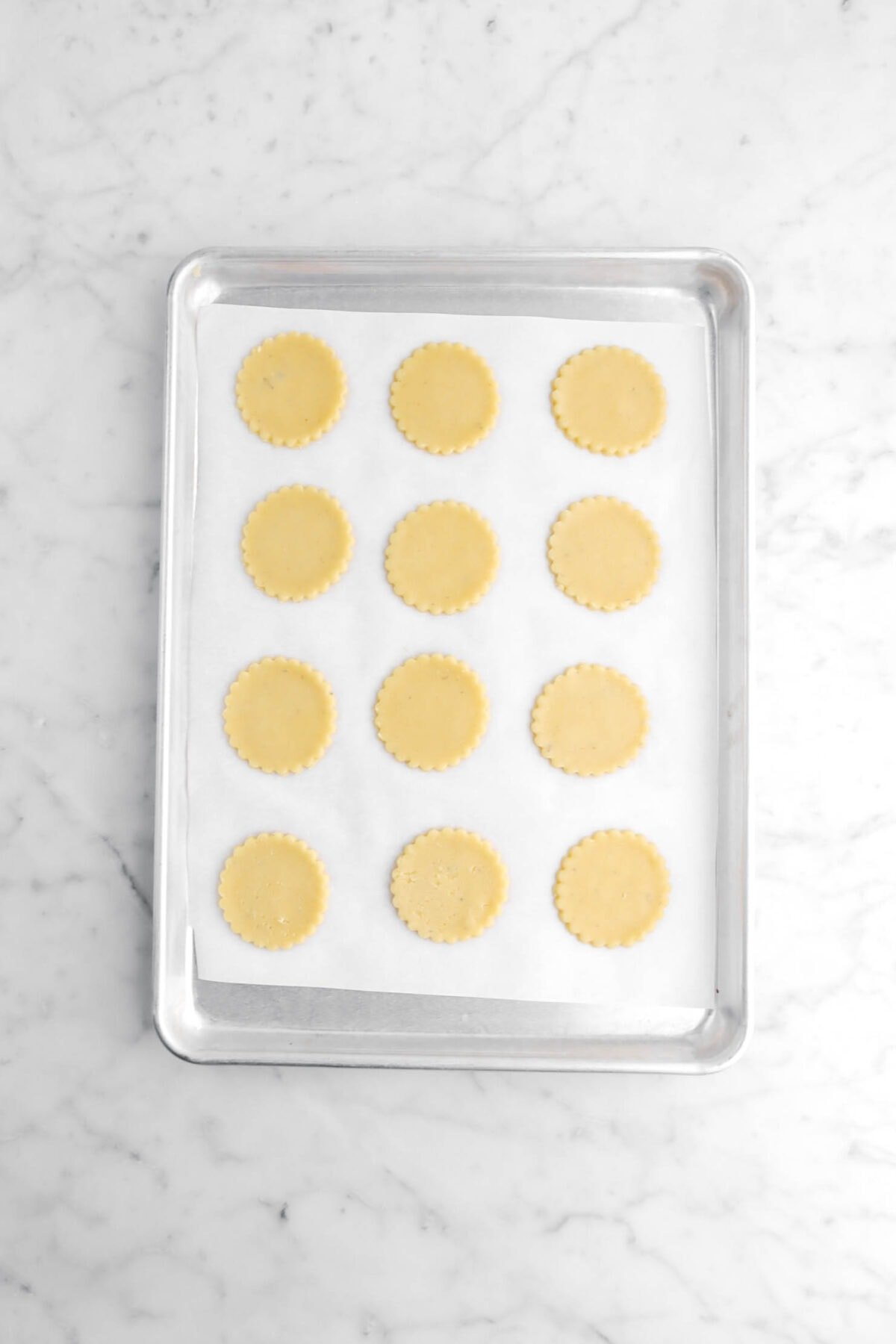 twelve unbaked cookies on sheet pan.