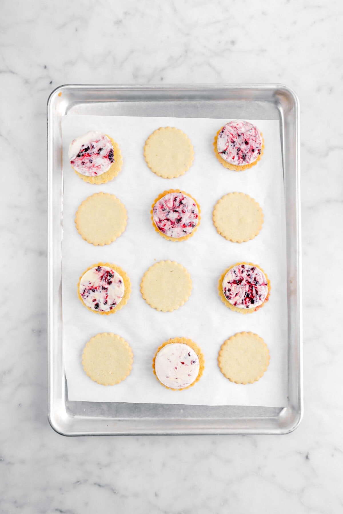 six circles of ice cream on top of six upside down cookies with six other cookies beside.