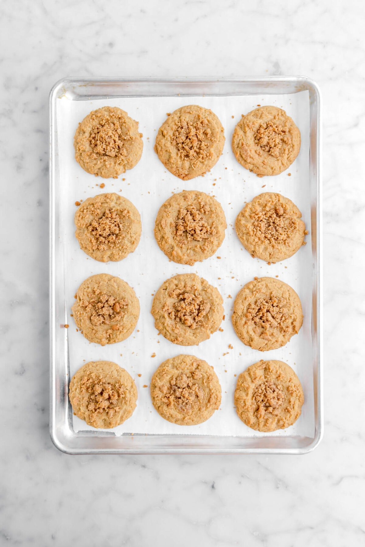 twelve baked coffee cake cookies on parchment lined sheet pan.