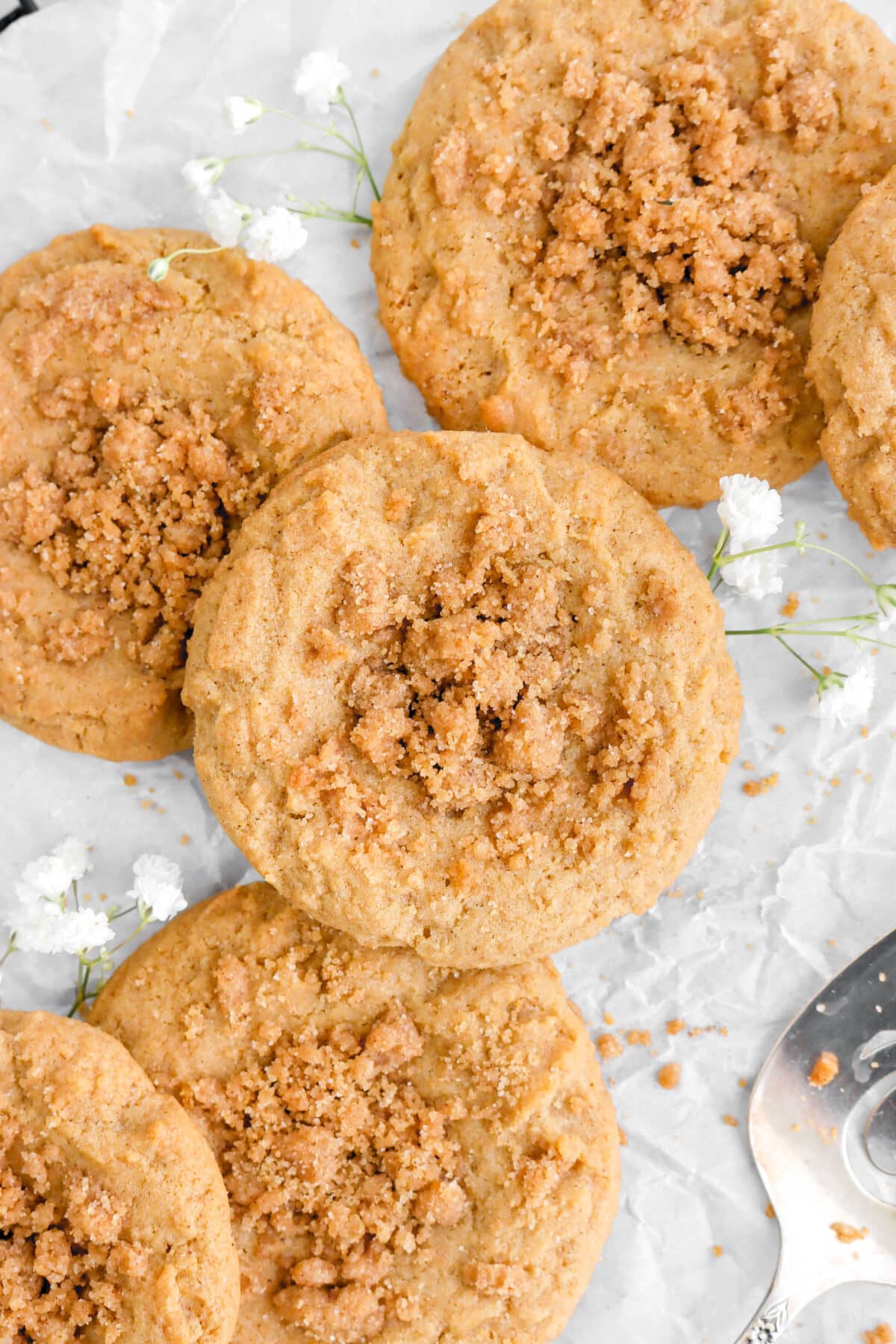 overhead close up of coffee cake cookies on parchment paper white flowers around.
