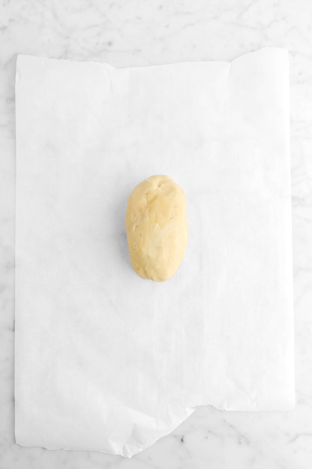 shortbread dough in oval shape on parchment paper.