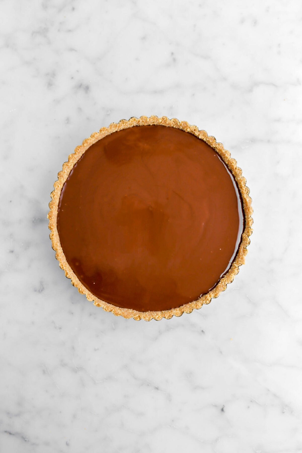 melted chocolate in graham cracker crust.