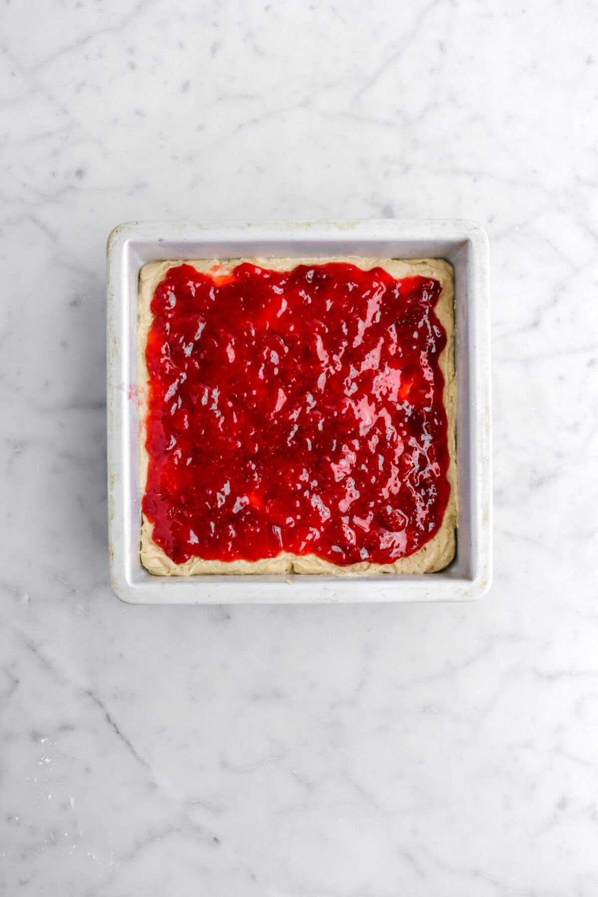 strawberry jam on top of cake batter.