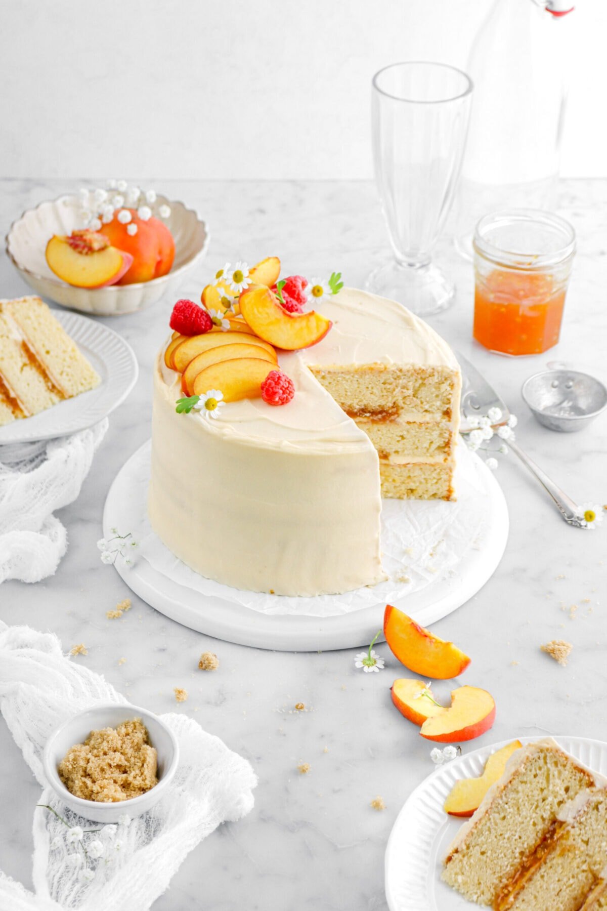 angled shot of peach cake on upside down plate with two slices of cake in front and behind the cake.