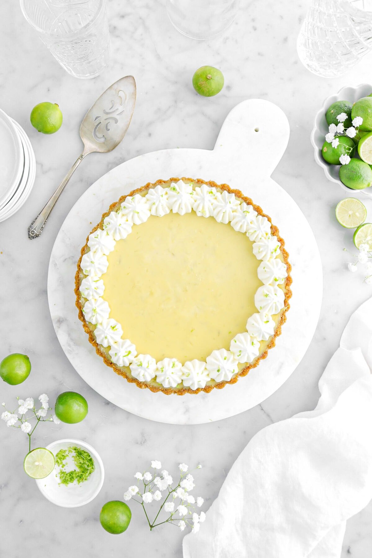 pie on marble serving tray with key limed snd white flowers around on marble surface.