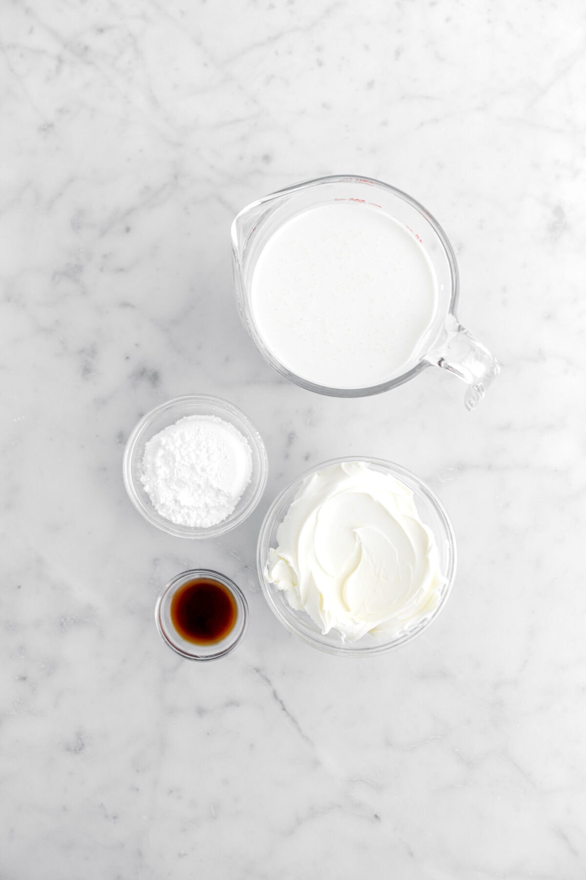 heavy cream, powdered sugar, vanilla, and mascarpone on marble surface.