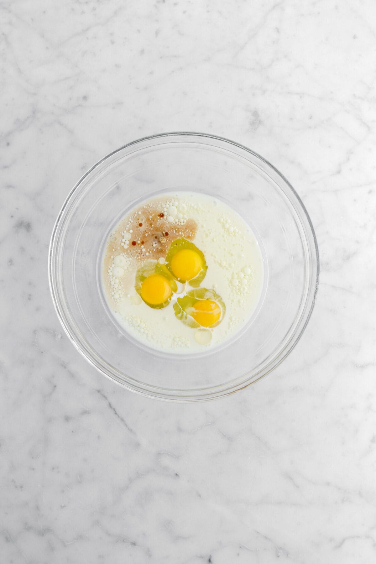 eggs, milk, oil, and vanilla in glass bowl.