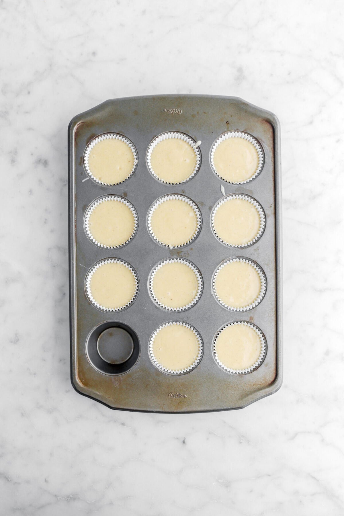 11 unbaked cupcakes in muffin pan.