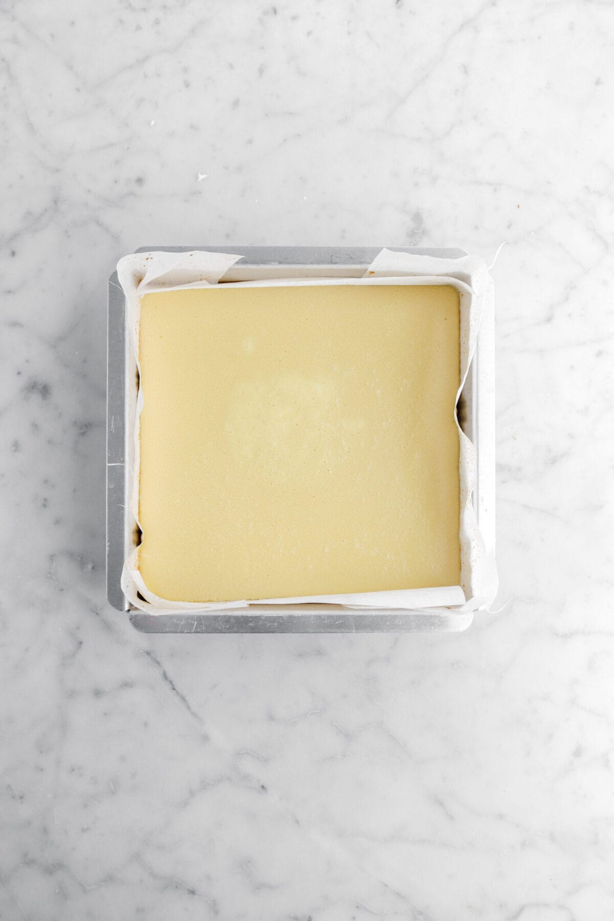 Par-baked maple cheesecake in lined square cake pan.