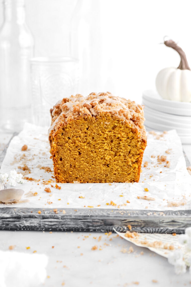 cut pumpkin bread on upside downs sheet pan with parchment paper and streusel crumbs around.