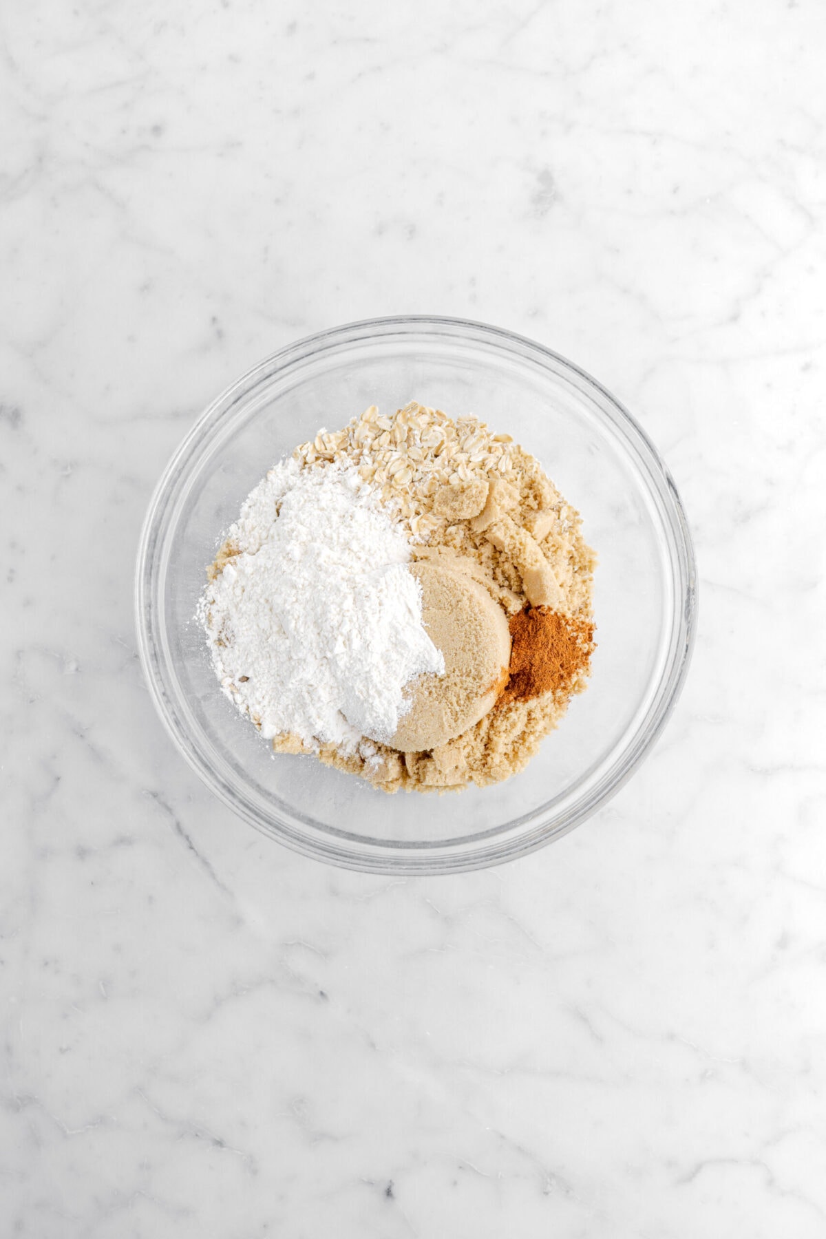 flour, brown sugar, oats, and cinnamon in glass bowl.