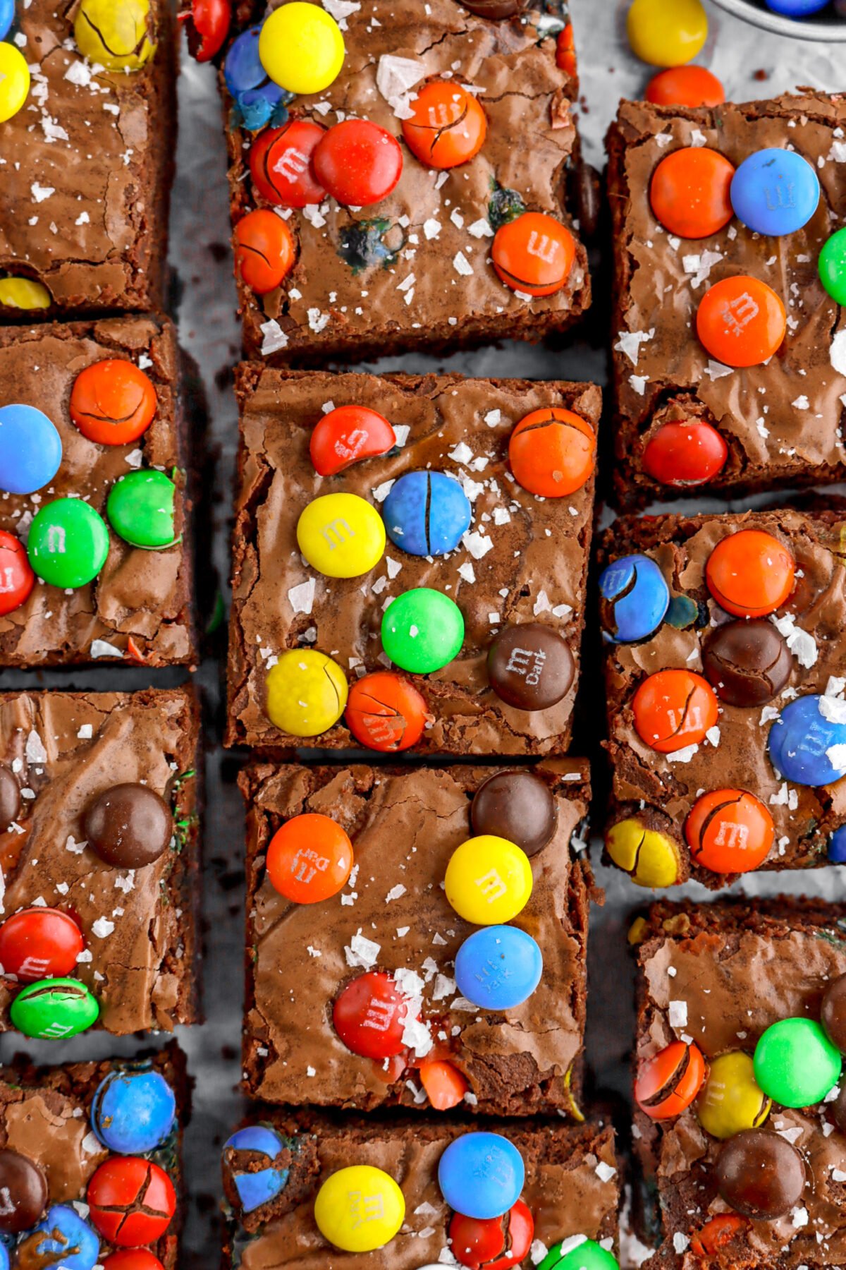 close up overhead image of M&M brownies with flaked salt on top.