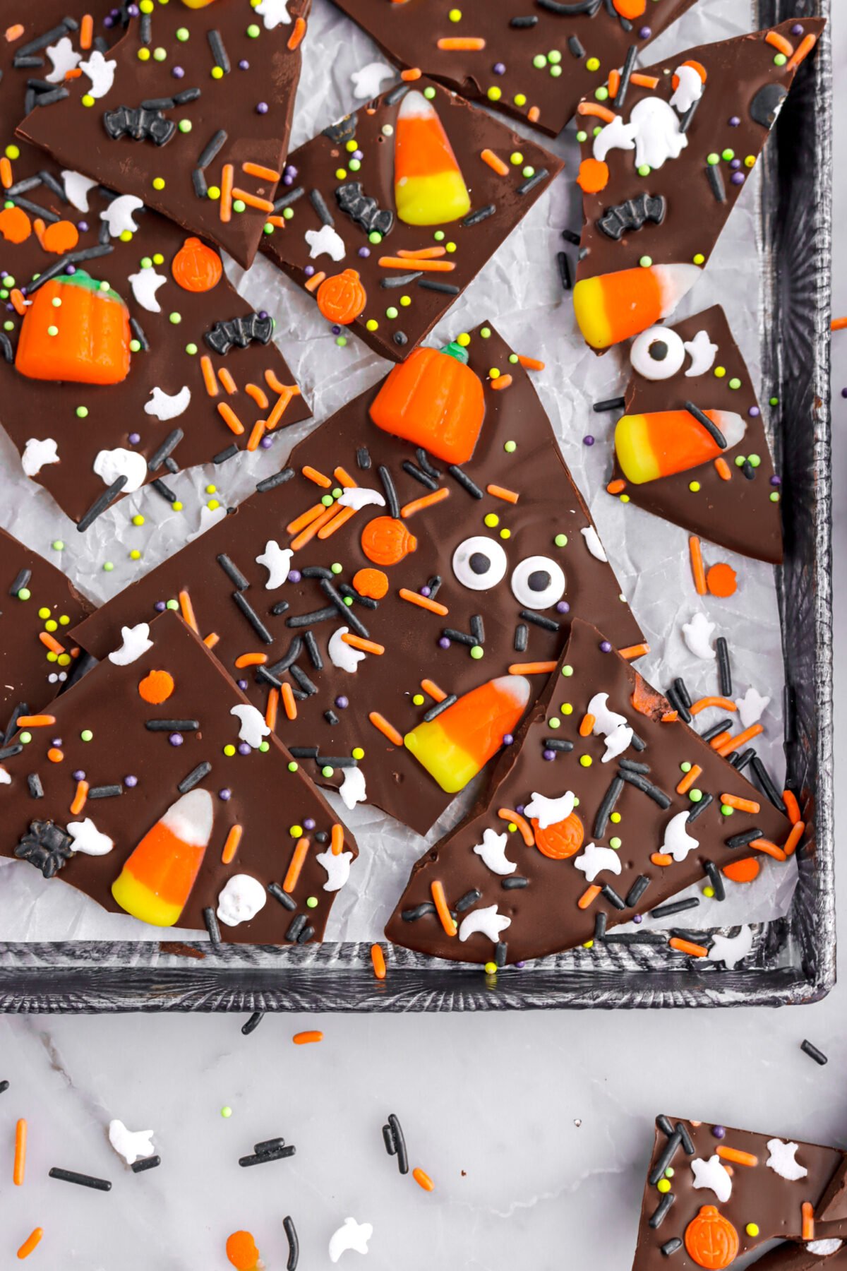cropped overhead image of candy bark on lined sheet pan.