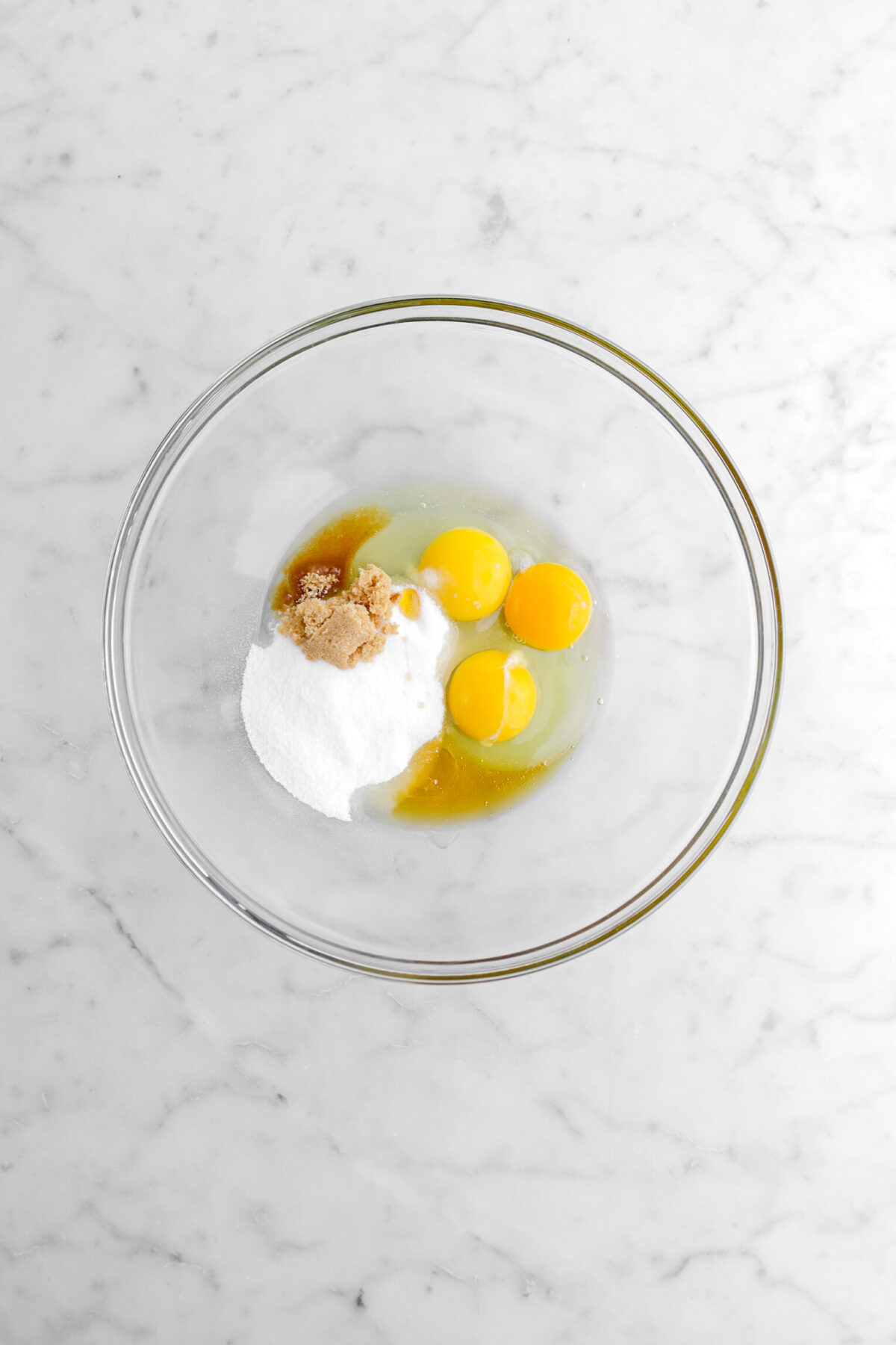 eggs, sugar, brown sugar, honey, and vanilla in glass bowl.