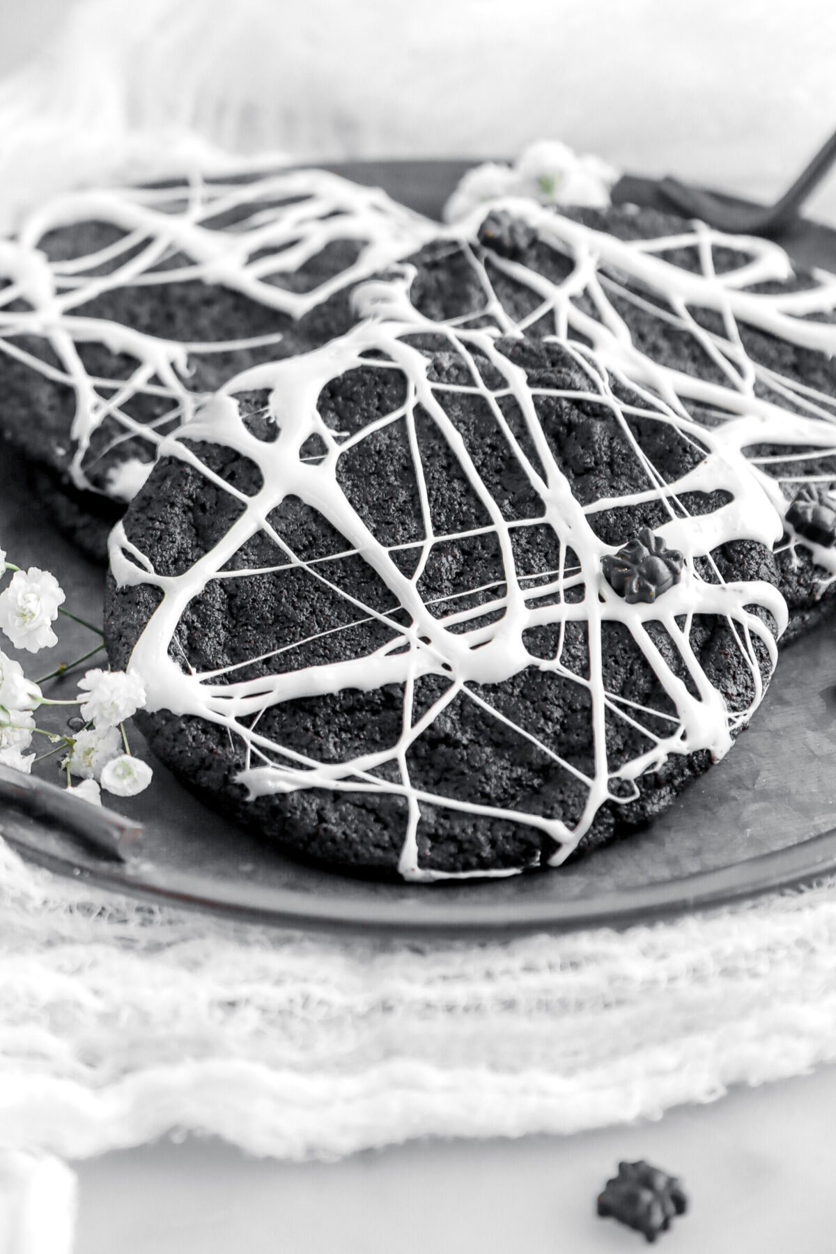 close up of spider web cookie with small sider shaped sprinkle on top.