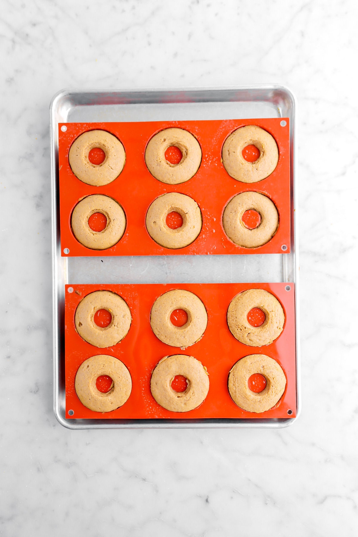 baked donuts in silicon pans on sheet pan.